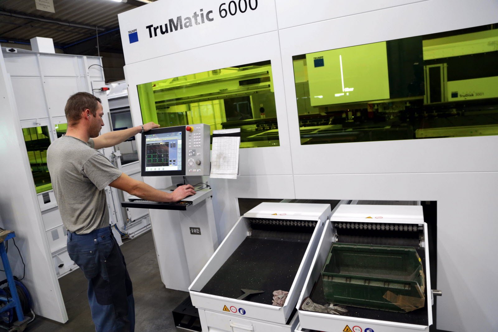Technicien programmant le pupitre de commande d'un centre de découpe Trumpf TruMatic 6000