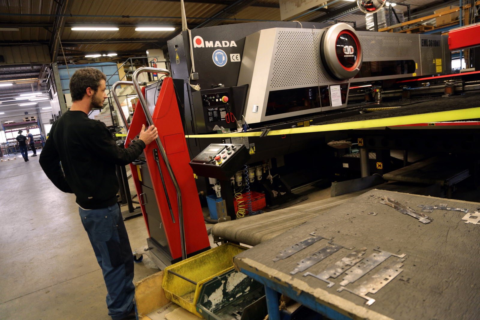 Opérateur surveillant la poinçonneuse Amada EML 3610NT en atelier Plimetal